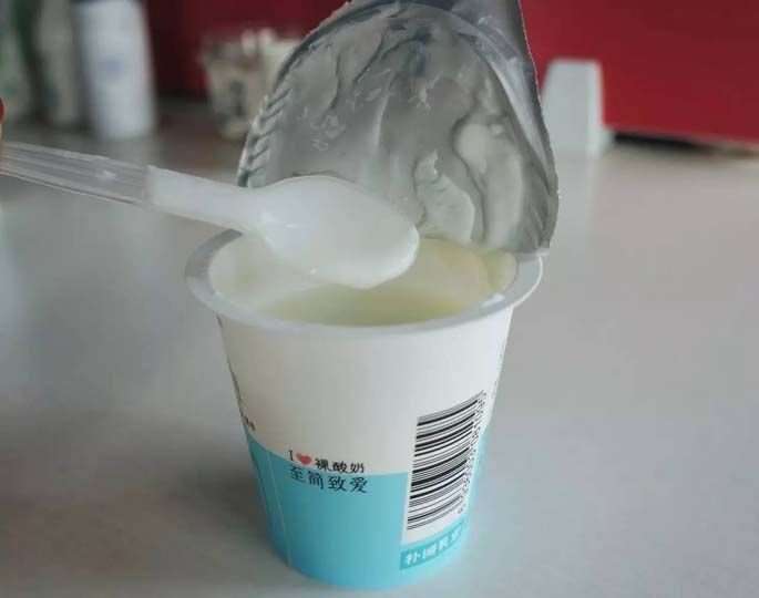 Taza de yogur hecha por la máquina llenadora.